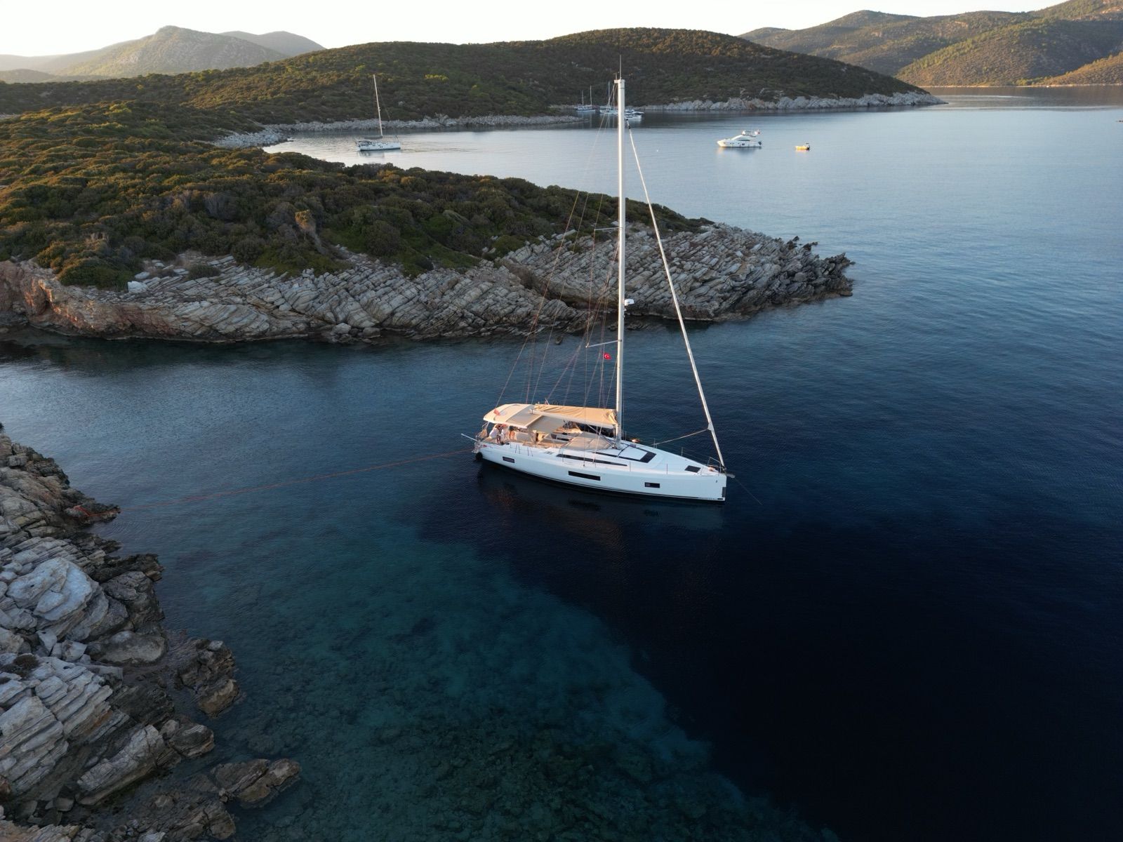 The Oceanis 51.1 anchored stern-to in a quiet cove at first light