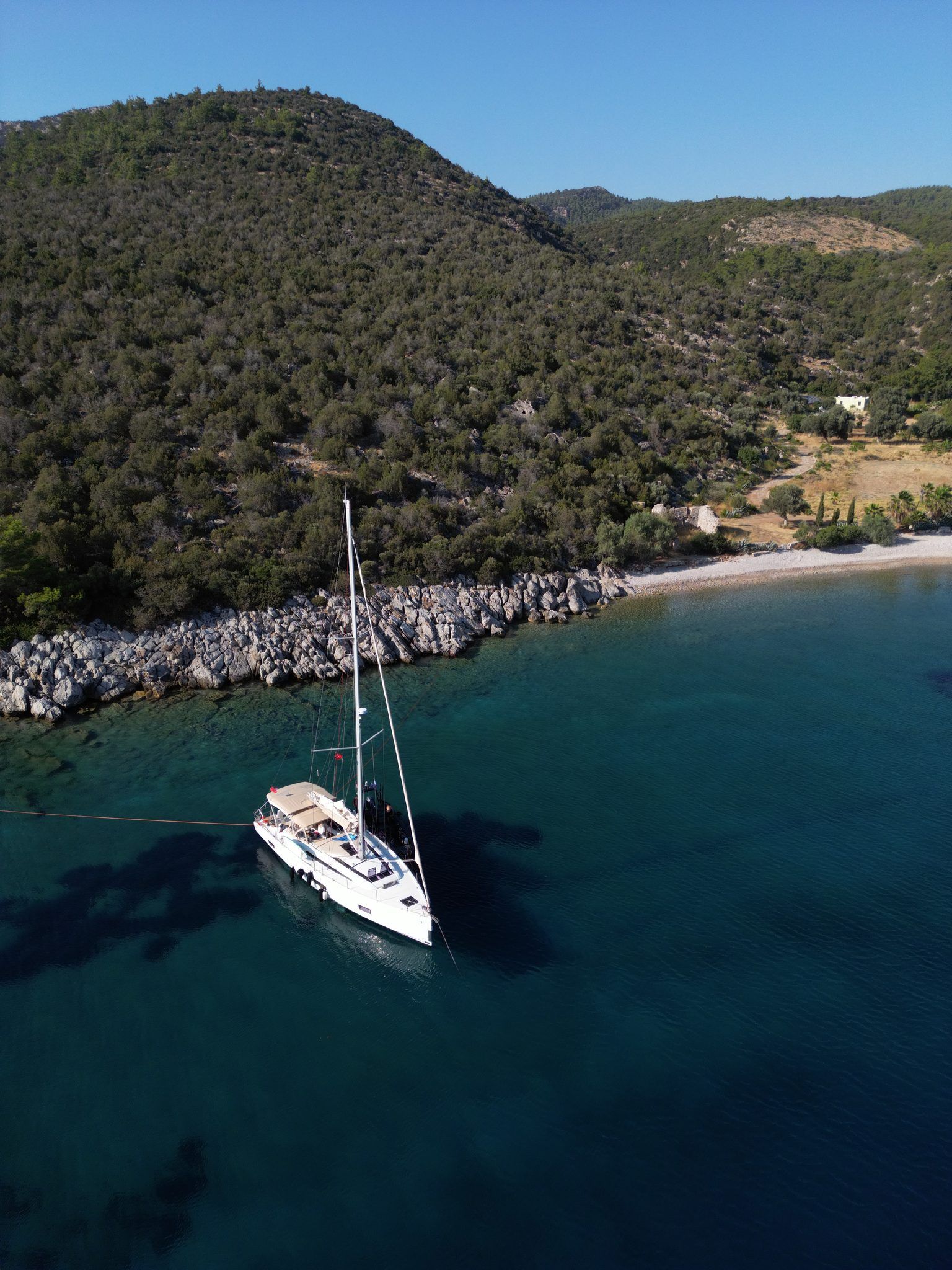 Anchored by a rocky shoreline, beach behind
