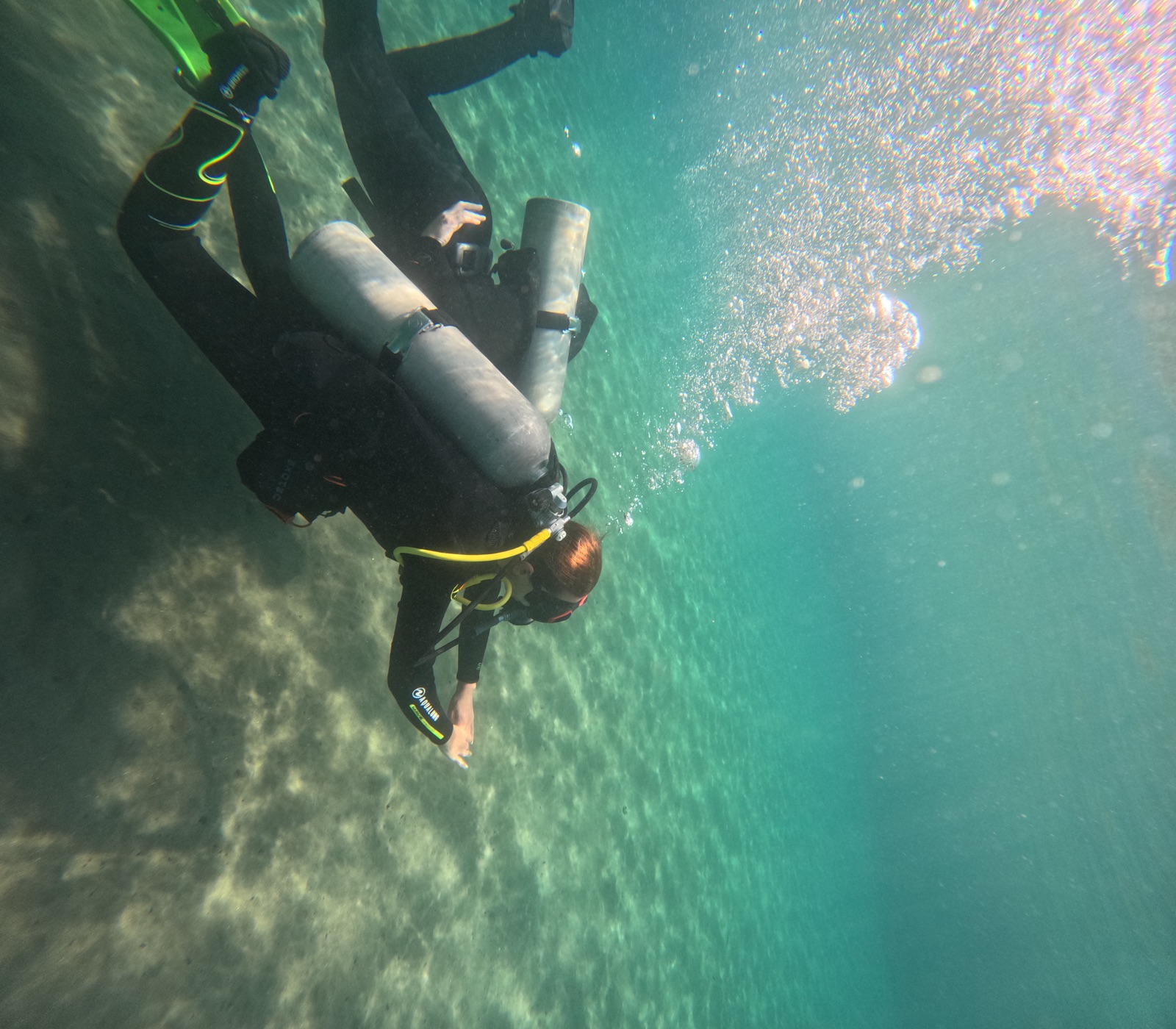 New diver swimming confidently over the sand