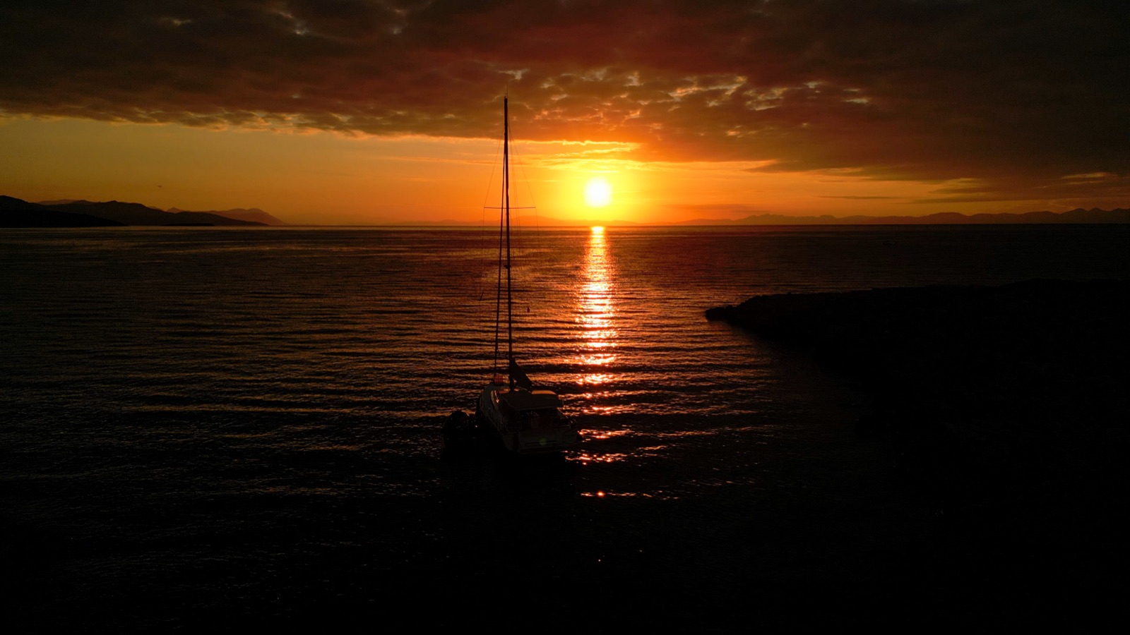The Oceanis at anchor, silhouetted against the sunset